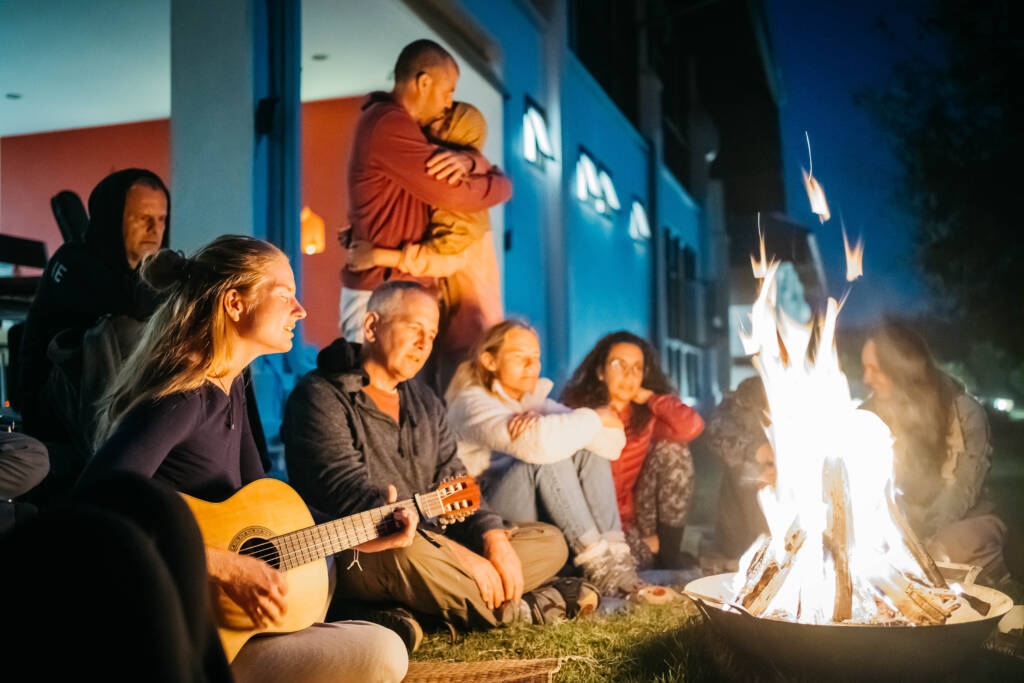 Kirtan gathering by the fireplace near the dining hall